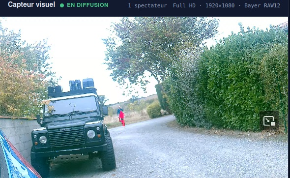 Vision visible avec fusion thermique XPLOCAM : information thermique superposée sur une personne dans une cour arborée